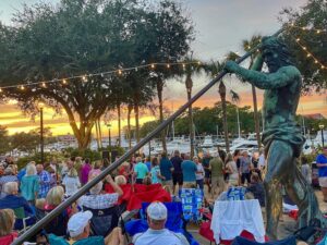 sunset over neptune statue with a crowd at Music & Taste